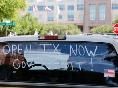 A message painted on a truck windshield promoted the reopening of Texas during a rally Saturday in front of the George A. Purefoy Municipal Center in Frisco.