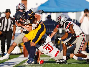 Highland Park wide receiver Luke Herring is brought down by the Flower Mound Marcus defense...