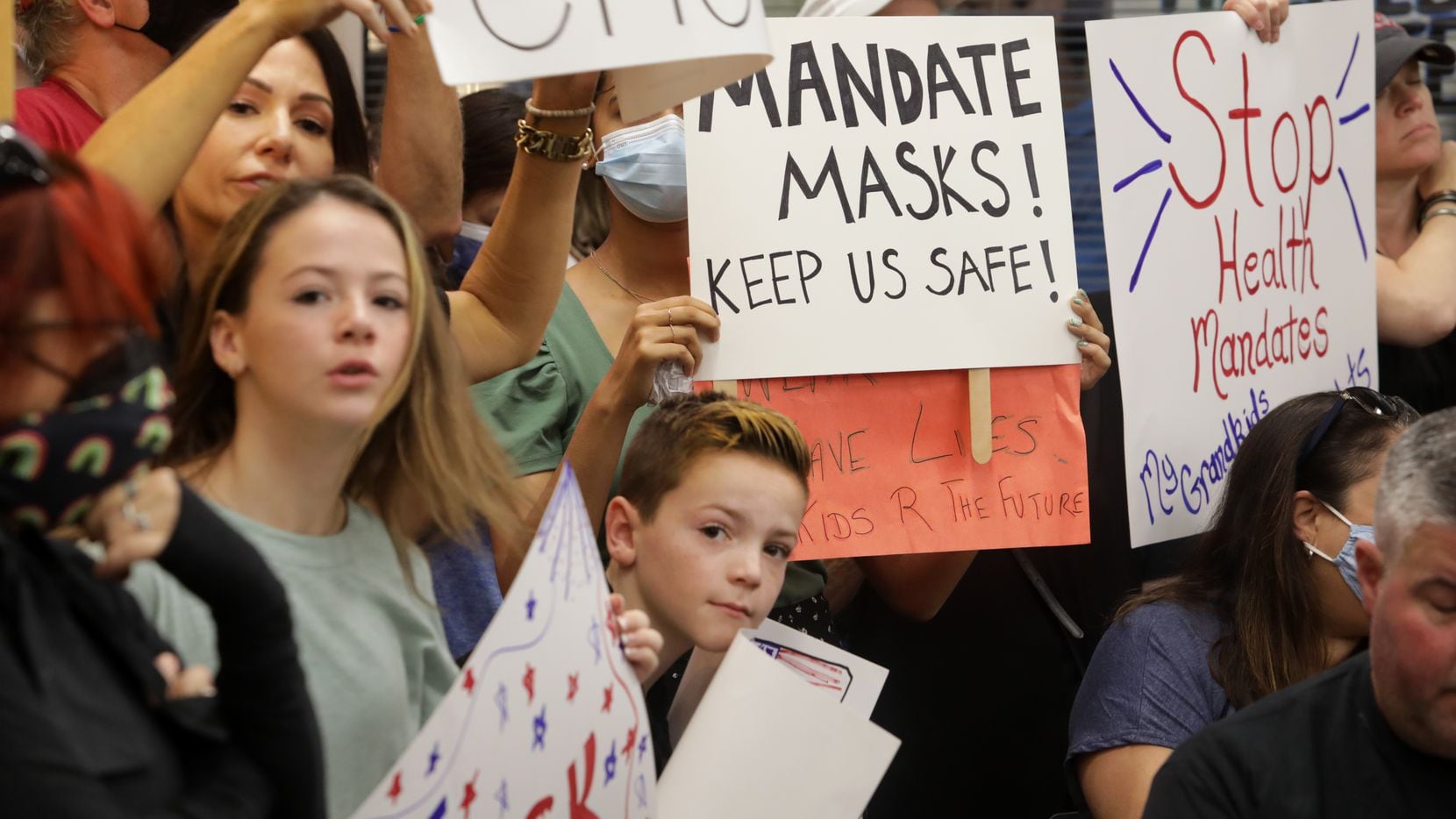 Community members on both sides of the masking debate gathered Monday during an emergency...