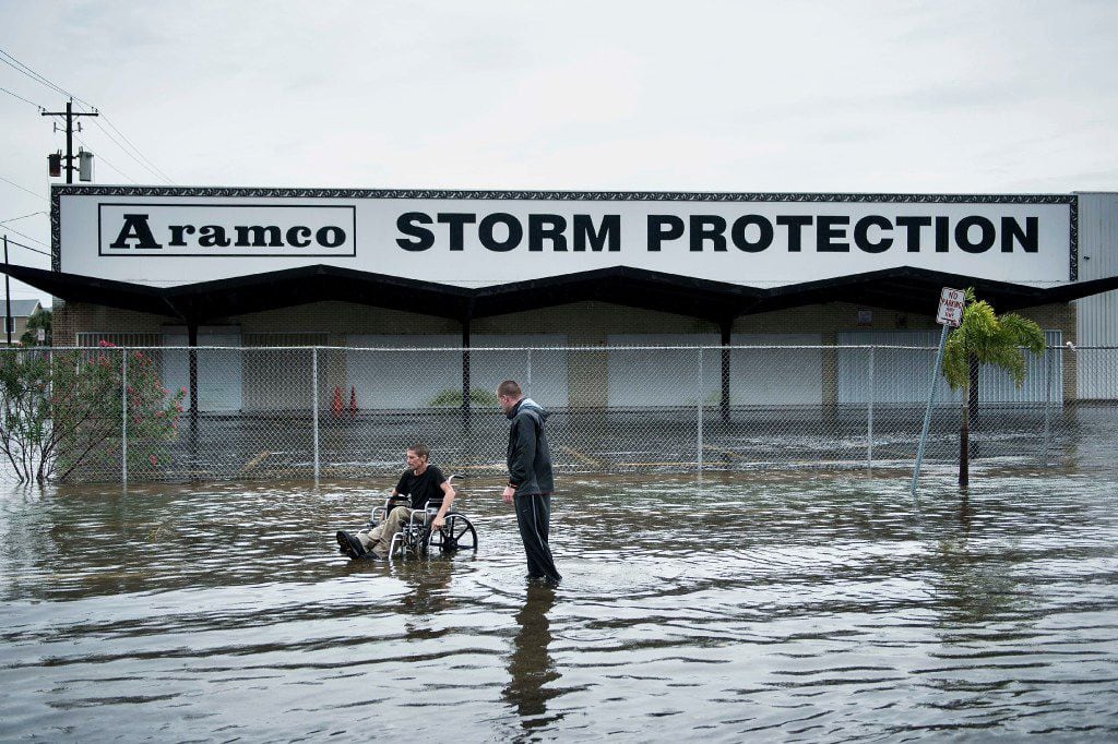 Brad Matheney offers help to a man in a wheelchair in a flooded street while Hurricane Henry passes through Texas August 26, 2017 in Galveston, Texas.
Hurricane Harvey left a trail of devastation Saturday after the most powerful storm to hit the US mainland in over a decade slammed into Texas, destroying homes, severing power supplies and forcing tens of thousands of residents to flee.