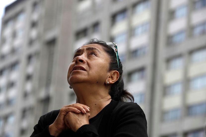 Una mujer no identificada reza durante la celebración de una misa católica en una plaza en...