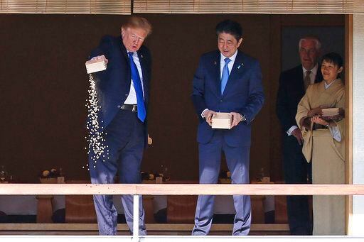 El presidente estadounidense Donald Trump arroja el resto del alimento para peces en un...