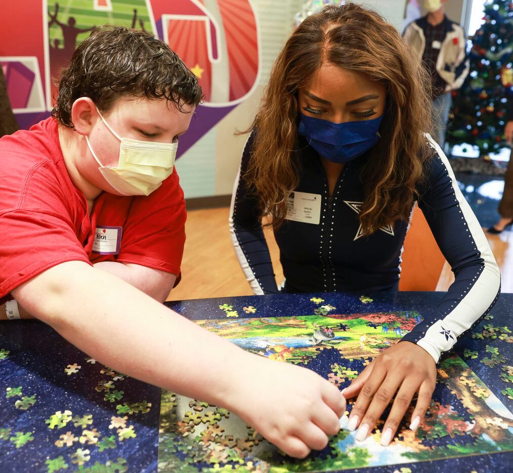 Sergei Allen and Dallas Cowboys cheerleader Armani Latimer work on a puzzle together at...