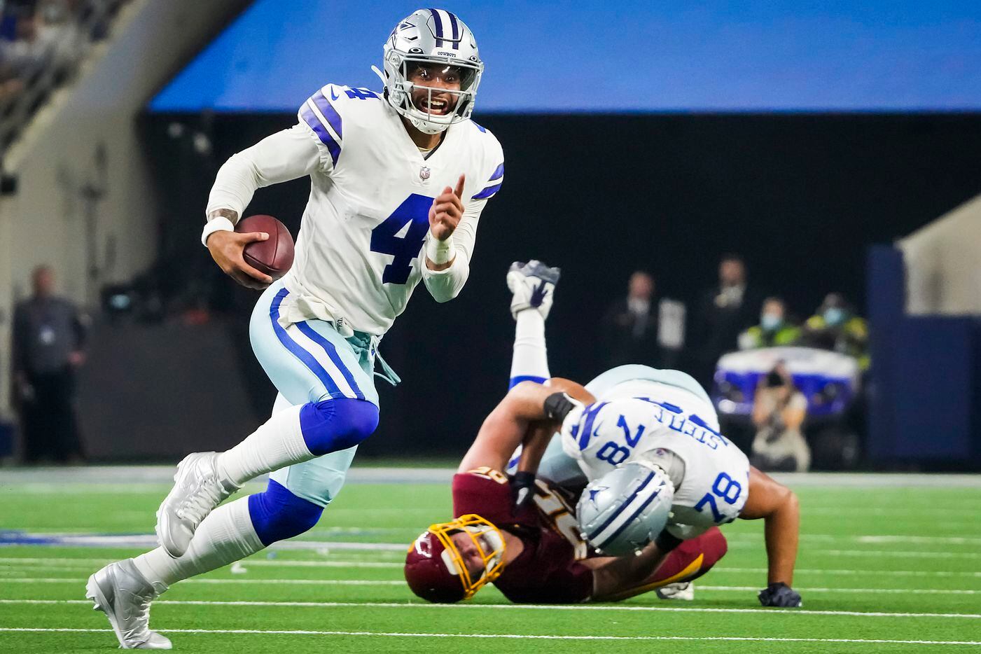 Dallas Cowboys quarterback Dak Prescott (4) gets a block from offensive tackle Terence Steele (78) as he scrambles for a first down during the first half of an NFL football game against the Washington Football Team at AT&T Stadium on Sunday, Dec. 26, 2021, in Arlington.