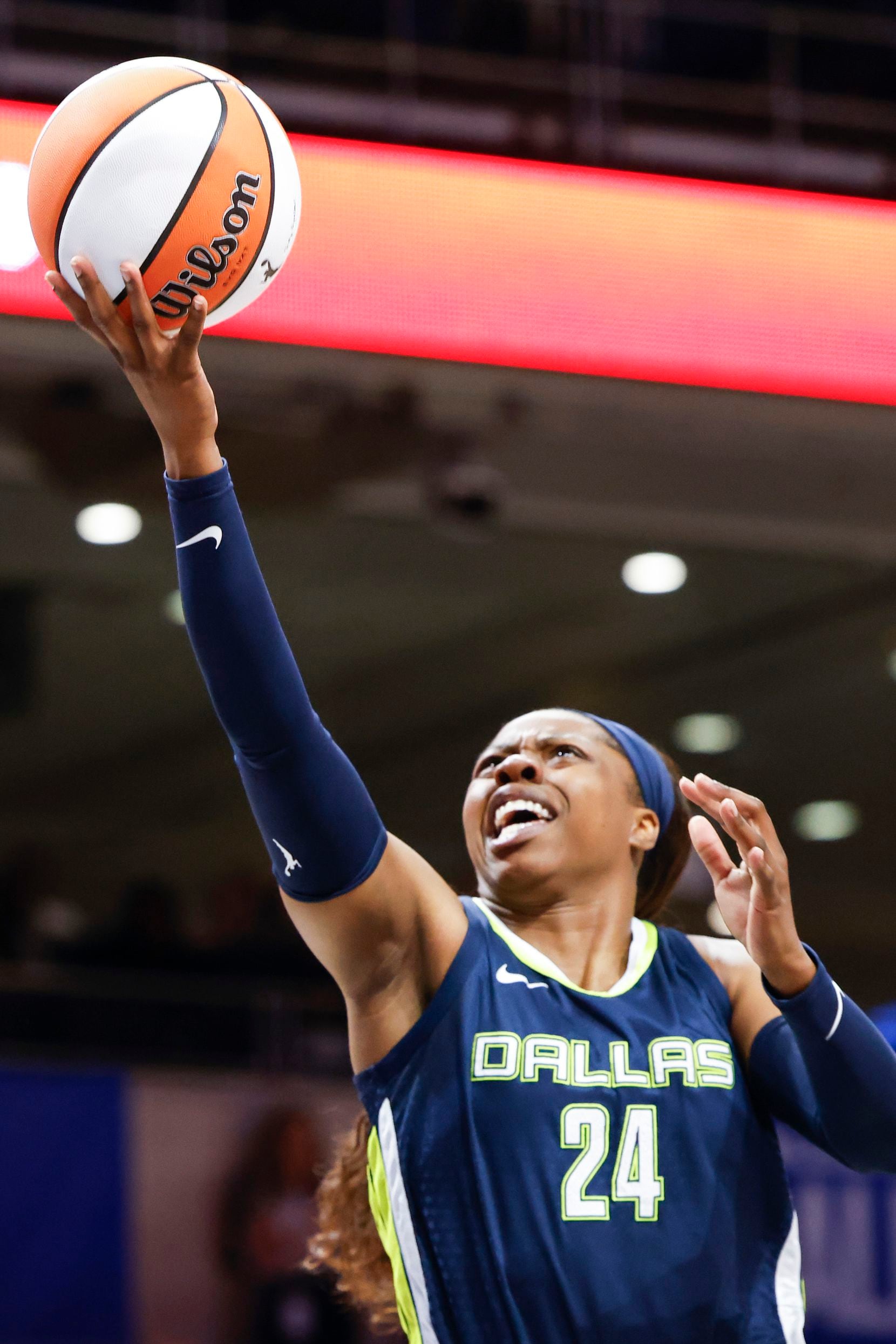 Dallas Wings guard Arike Ogunbowale scores during the first half of a WNBA basketball game...