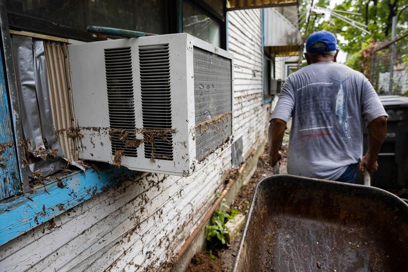 Juan Garcia walks by the waterline left on his home by the Monday morning floods on Tuesday,...