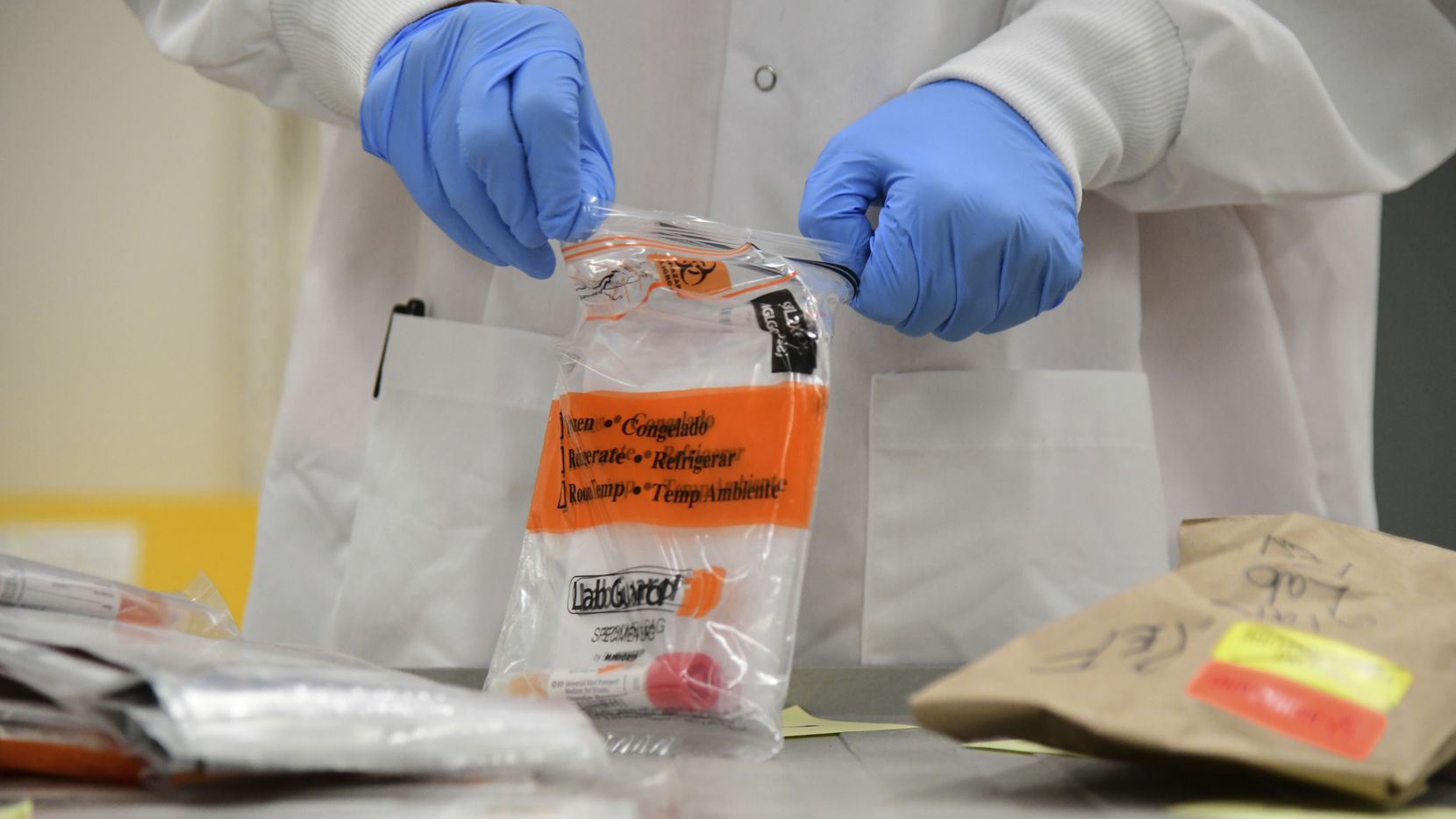 David Storey processes samples for a coronavirus test at the Colorado Department of Public...