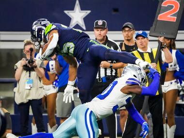 Seattle Seahawks running back Travis Homer (25) is tripped up by Dallas Cowboys cornerback...