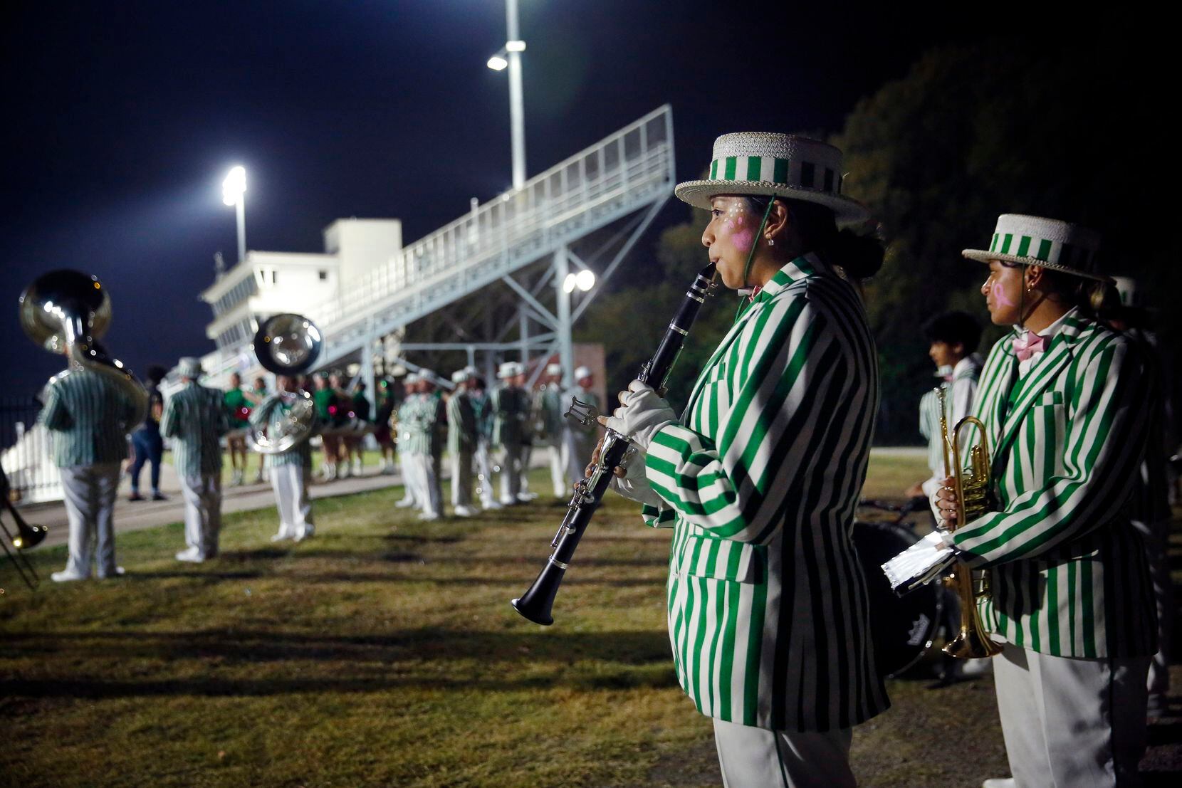 Members of the Bryan Adams High marching band member Jennifer Robles warms up on her...