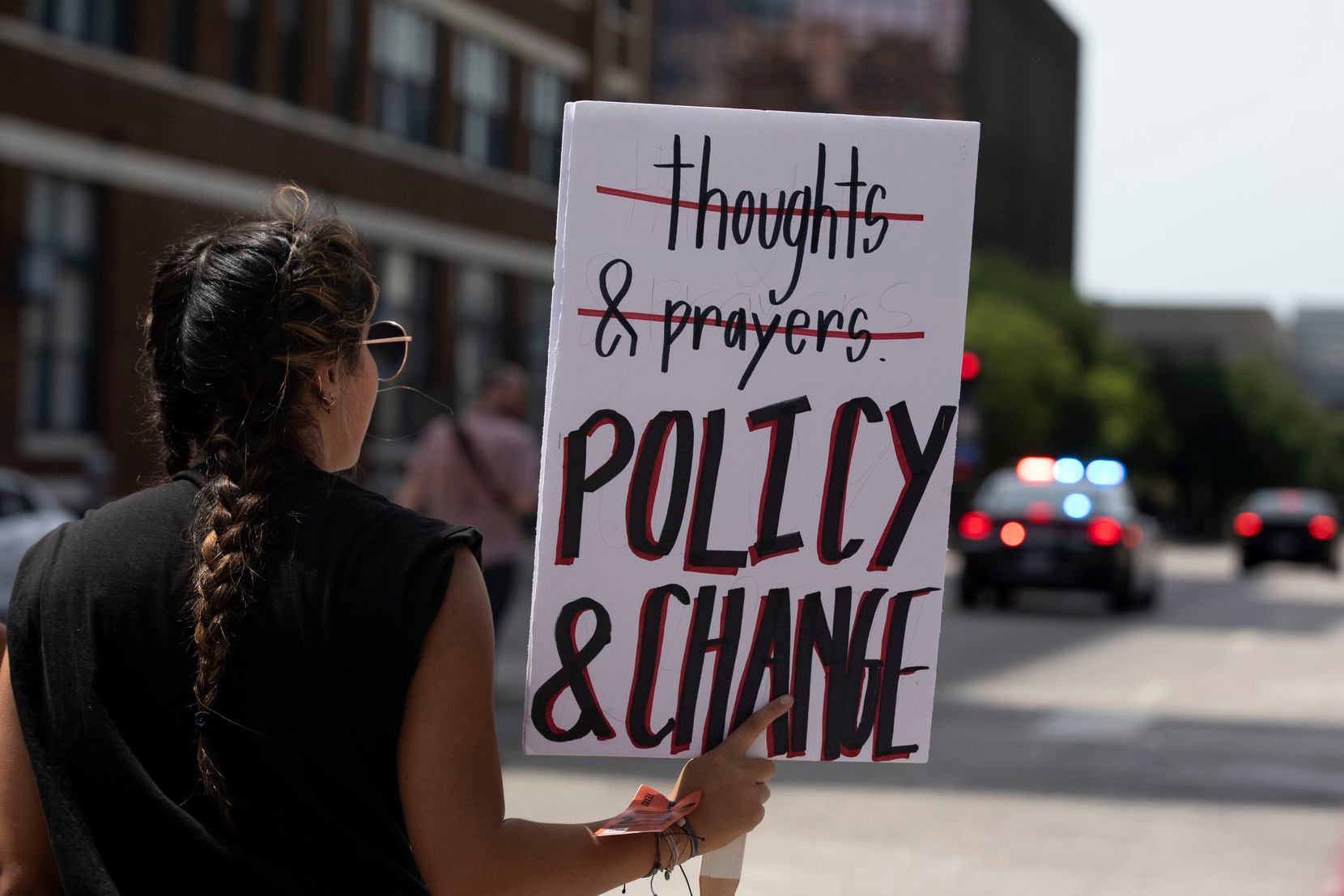 A protester holds a sign calling for policy change during Saturday's demonstration in Dallas.