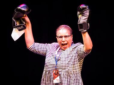 Tarrant Country Democratic Party chair Deborah Peoples holds up boxing gloves as she takes...