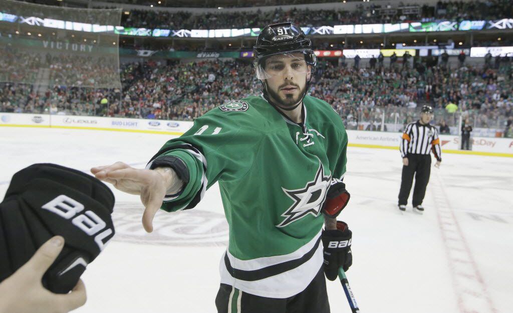 Dallas Stars center Tyler Seguin (91) reaches out for glove from the bench during the first...