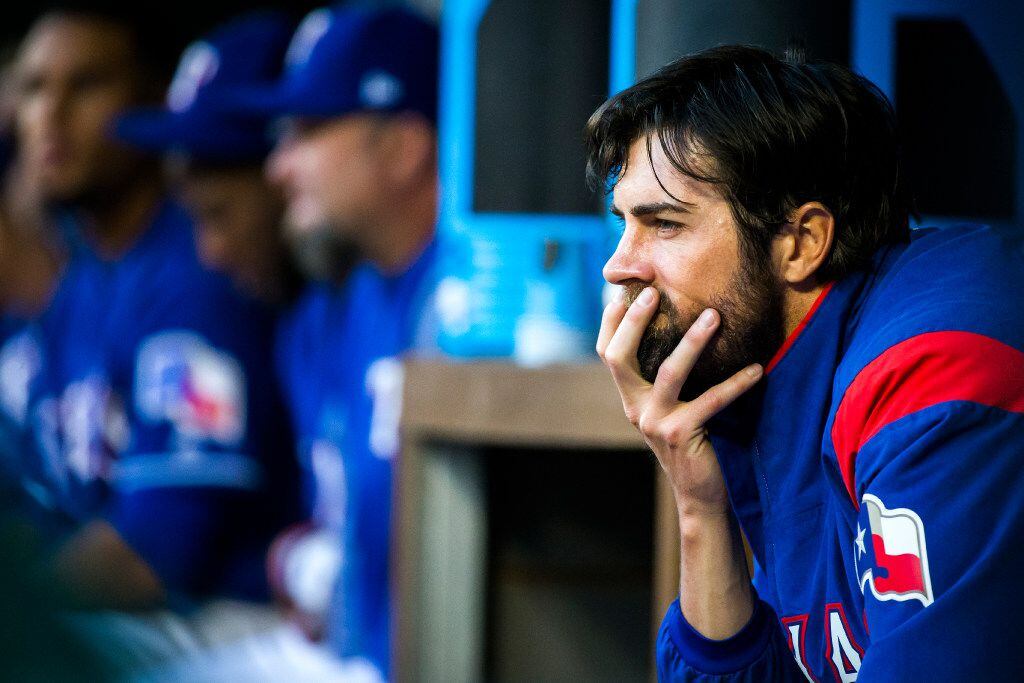 Texas Rangers starting pitcher Cole Hamels watches from the dugout during the second inning...