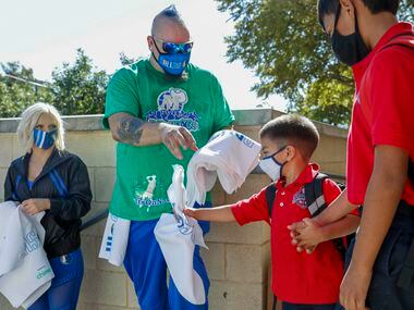 Mavs ManiAACs dancer Pro Zac gives a Dallas Mavericks towel to a student after the end of...