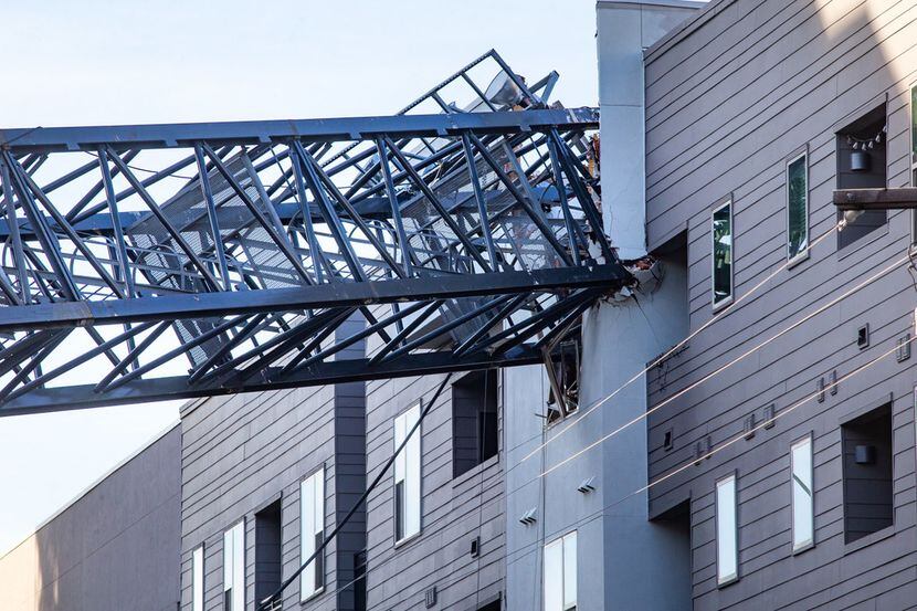 A crane remains embedded in the Elan City Lights apartment complex in Dallas on Friday. The...