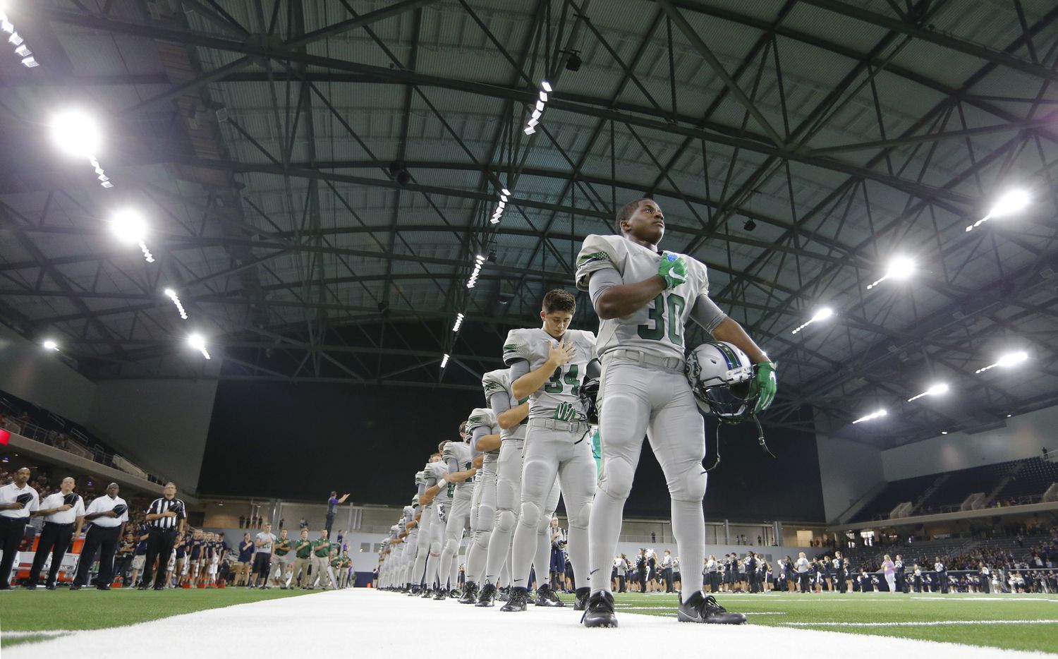 Reedy's Justin Gipson (30) and team during the National Anthem before playing against Independence High School in the first high school football game at The Star in Frisco on Saturday, Aug. 27, 2016.