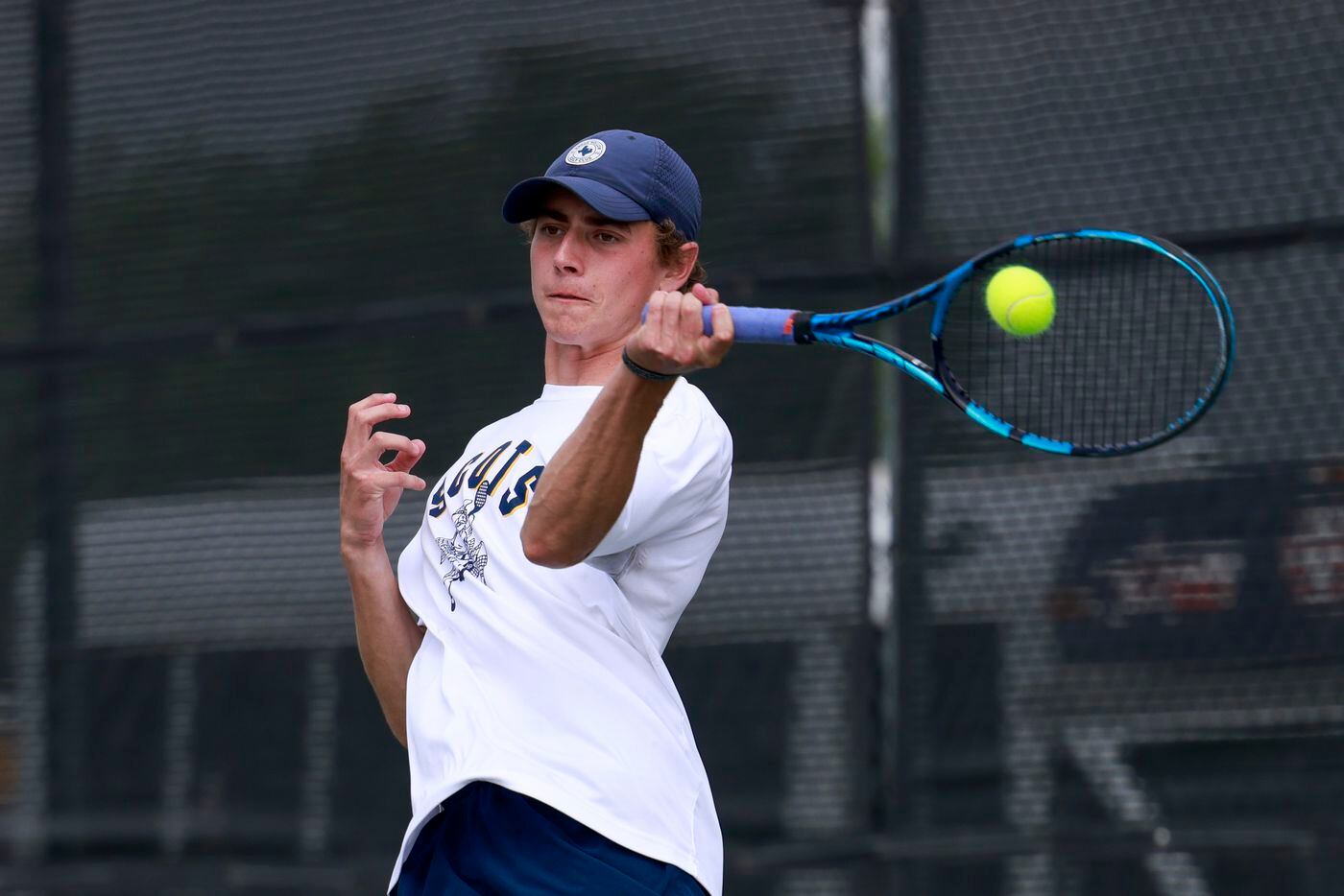 Highland Park’s Ray Saalfield jumps to hit a return shot during the 5A boys doubles...