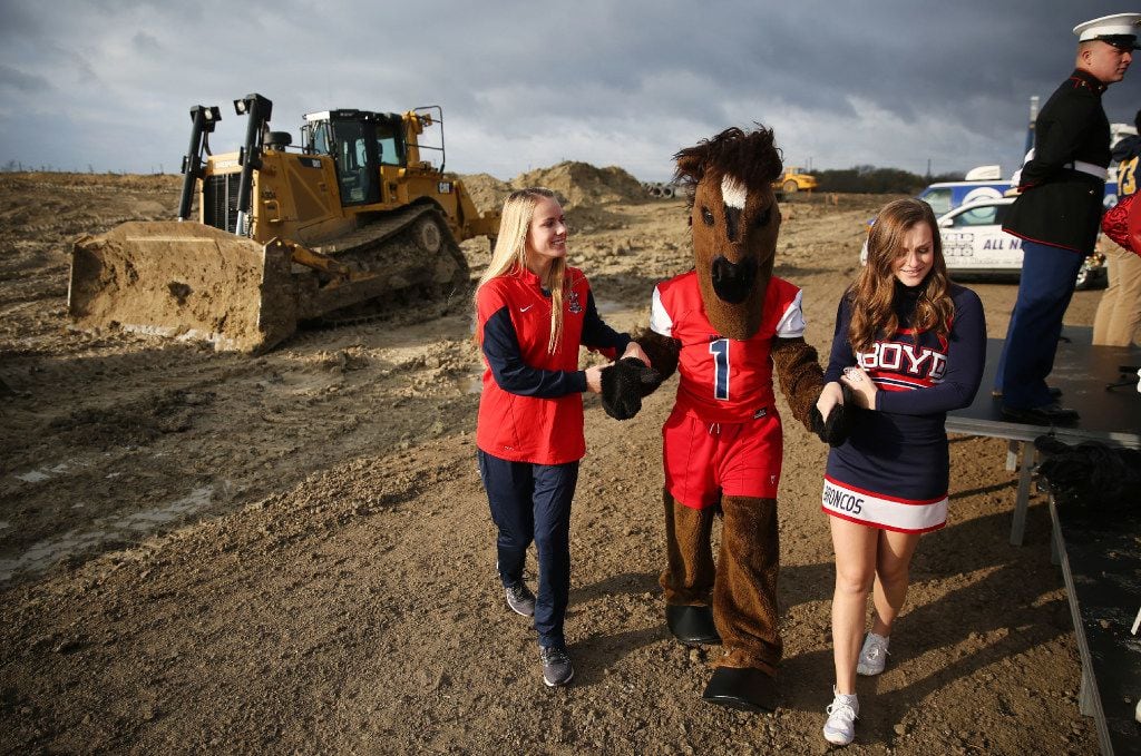 MicKinney Boyd seniors Avery Hall (left) and Olivia Simpson (right) help Becca Groskopf, who is dressed as the Boyd mascot, before participating in the groundbreaking ceremony for McKinney ISD Stadium and Community Event Center. (Andy Jacobsohn/The Dallas Morning News)