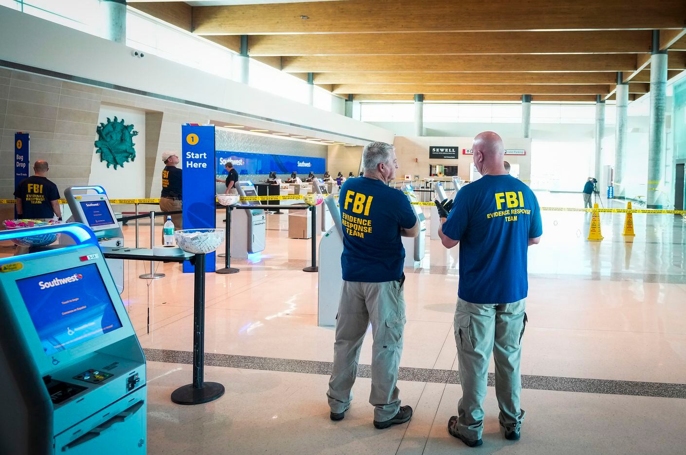 An FBI Evidence Response Team works inside the ticketing hall at Dallas Love Field Airport...