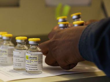 Medical assistant Symone Johnson prepares vials of lidocaine for patients who will be seen...