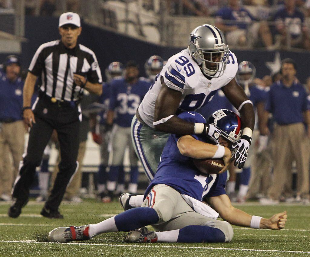 New York Giants quarterback Eli Manning (10) is sacked by Dallas Cowboys defensive end...