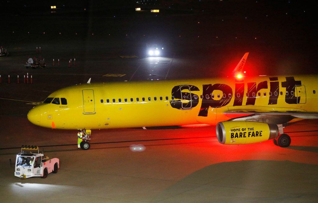 Grounds crew workers ready a Spirit Airlines jet for takeoff at Dallas-Fort Worth International Airport, Wednesday evening, May 8, 2019. Nine airline workers from Envoy Air, Inc. and Spirit Airlines who were arrested a year ago for plotting to smuggle drugs out of DFW Airport have agreed to plead guilty in the case.