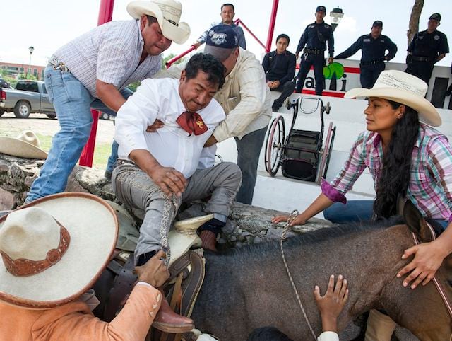 Salvador Espinoza recibe ayuda para montar su caballo en Cuautitlán Izcalli, en el Estado de...