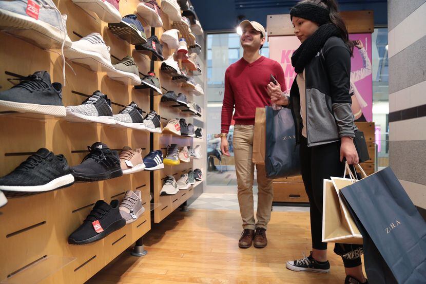 Mark Jiménez y Julie Aguilar compran zapatos en una tienda del Galleria Mall, el viernes por...