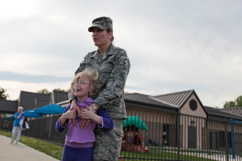 Then-Master Sgt. Tracy Demarco holds her daughter Rachel, 4, at the daycare she attended at...