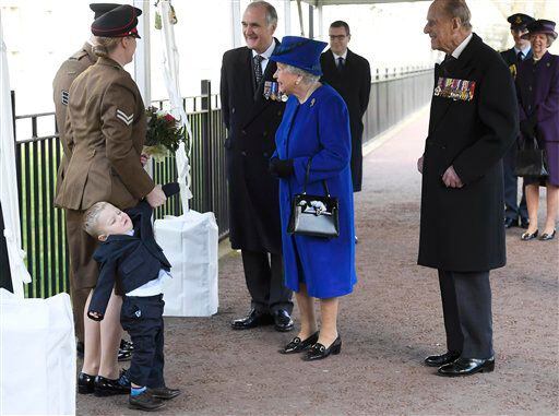 Michelle Lun, izquierda, aferra la mano de su hijo Alfie, de dos años, frente a la reina...