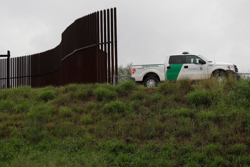 A U.S. Customs and Border Patrol agent passes along a section of border wall in Hidalgo, Texas.
