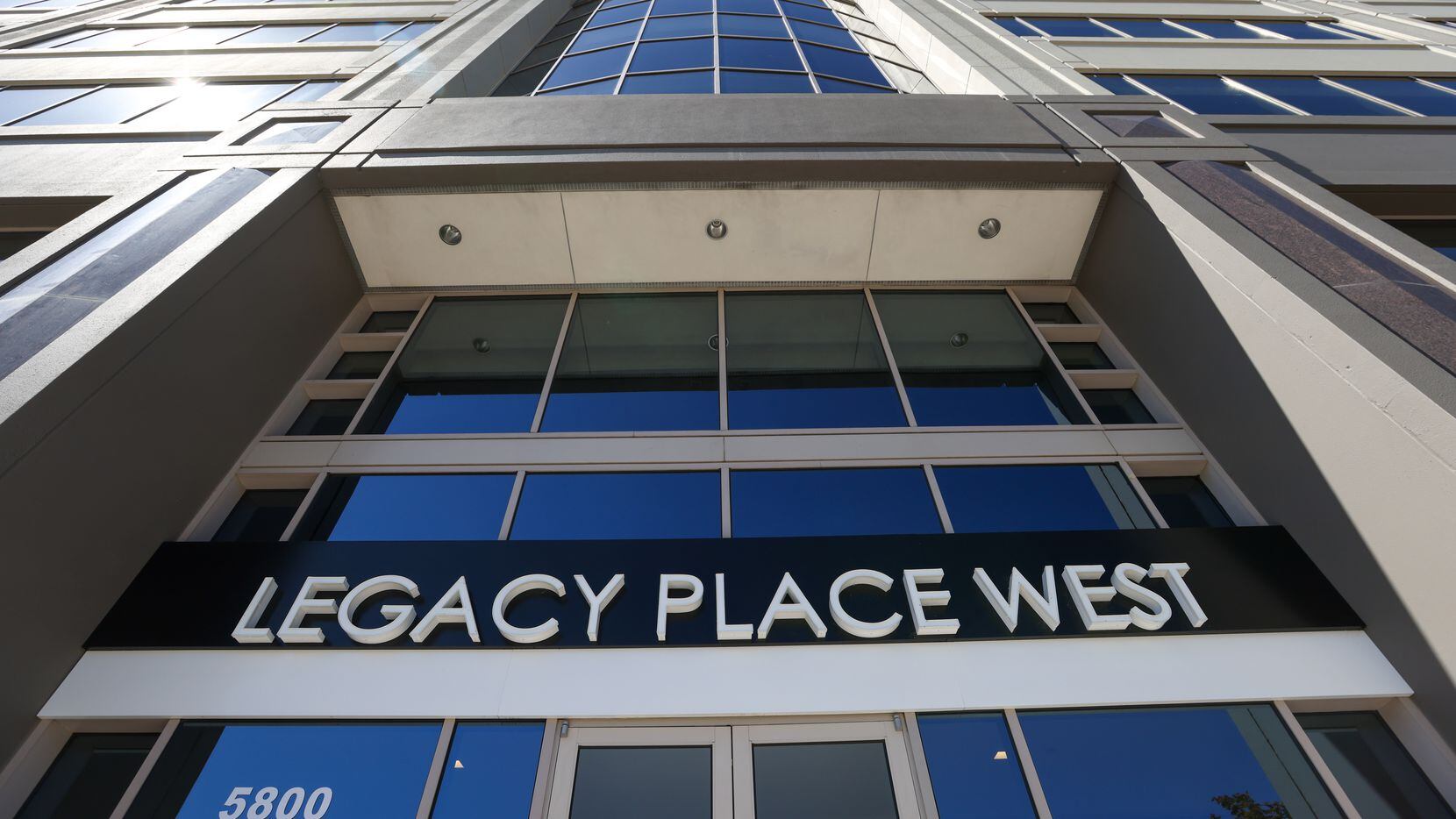 A sign marks the entrance to Legacy Place West. The building houses the Plano headquarters...