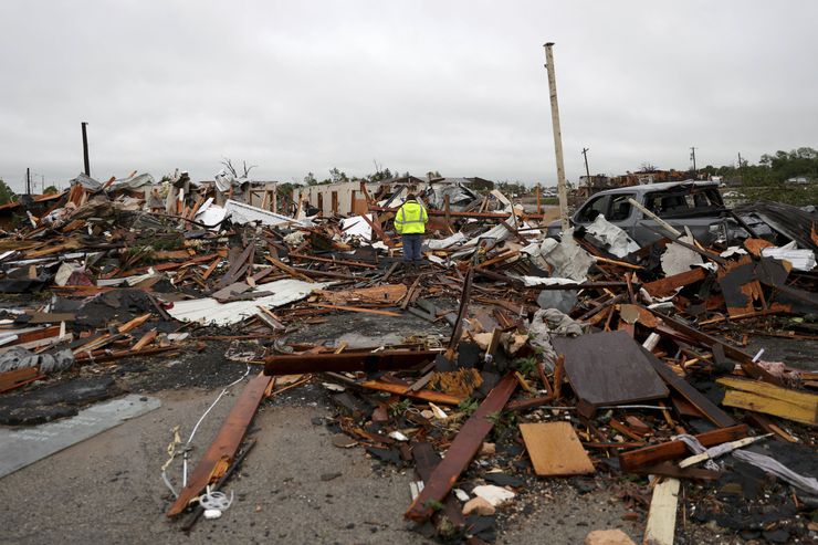 A man is surrounded by tornado damage after severe storms moved through the night before in...