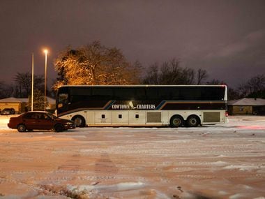 Marleny Almendarez's car is parked next to a charter bus that serves as a warming center for...