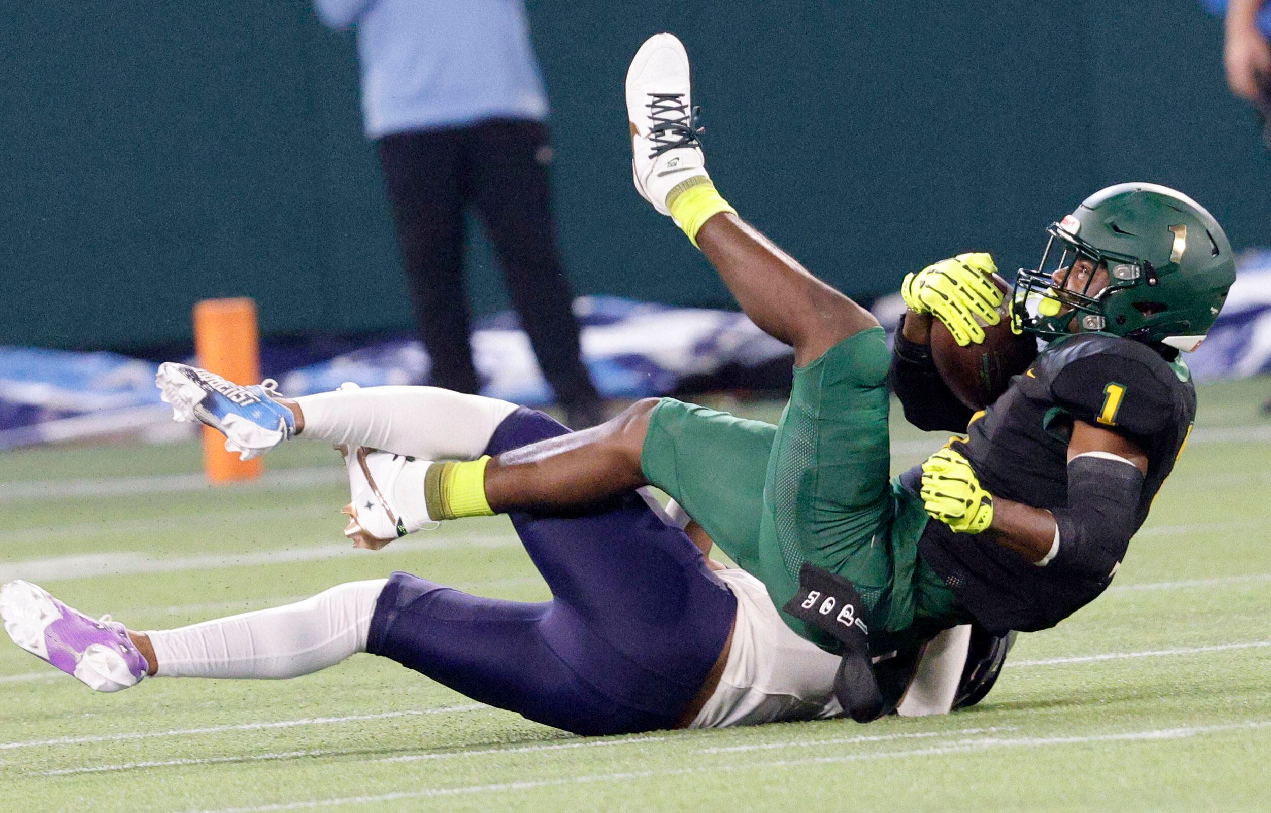 DeSoto's Deondrae Riden Jr. (1) is tackled by Wylie East's Michael Henderson (21) during the...