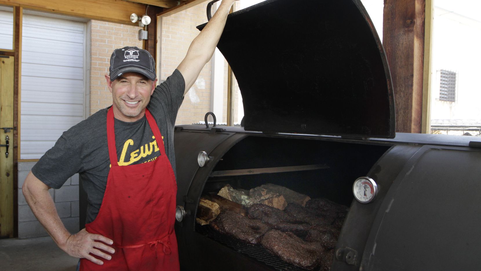 Co-owner Todd David opens the lid on his massive 1000-gallon smoker, Brutus, at Cattleack...