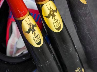 Texas Rangers outfielder Willie Calhoun’s bats and helmet sit ready in the dugout during a...