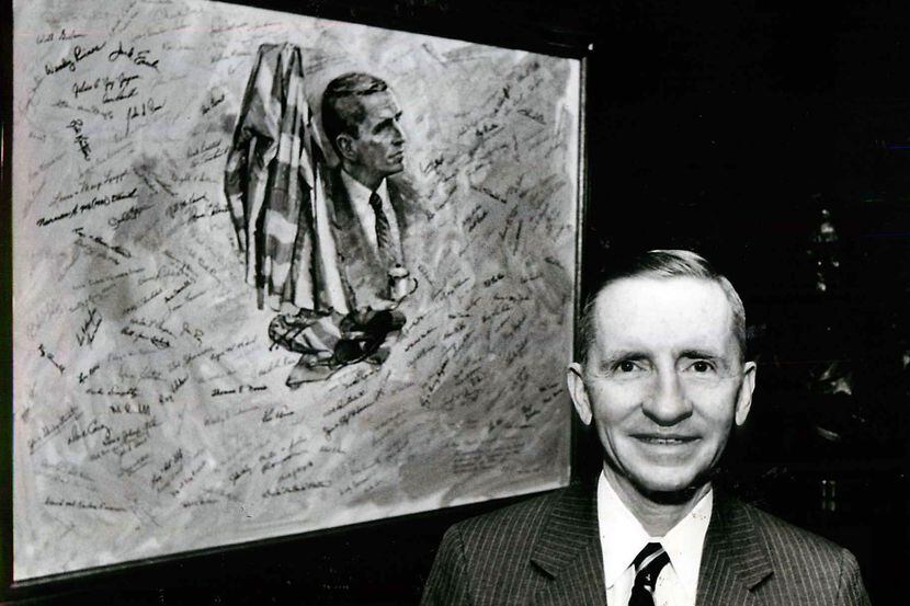 H. Ross Perot stands outside his office beside a painting autographed by many of the POWs he...
