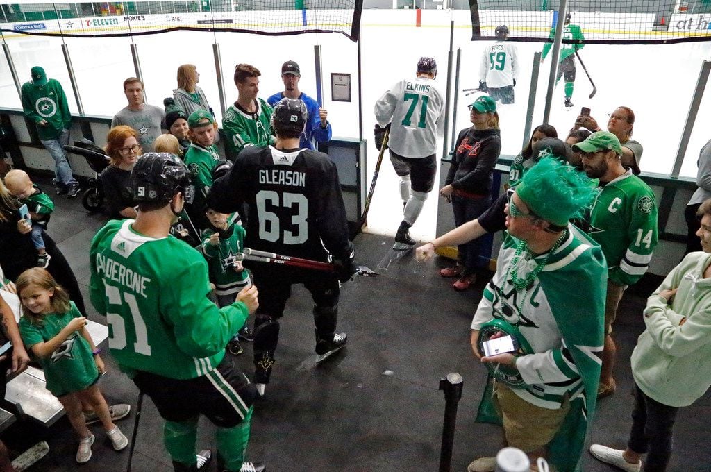 Dallas Stars players go through some of the fans on hand to take the ice for their third...