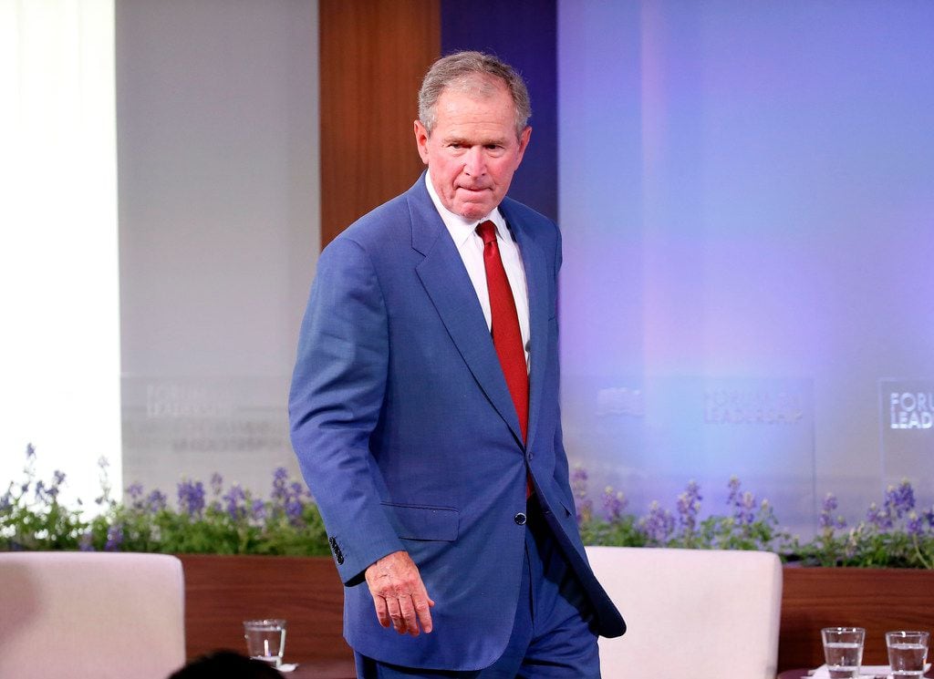 Former President George W. Bush walks off the stage after making remarks at the Forum on...