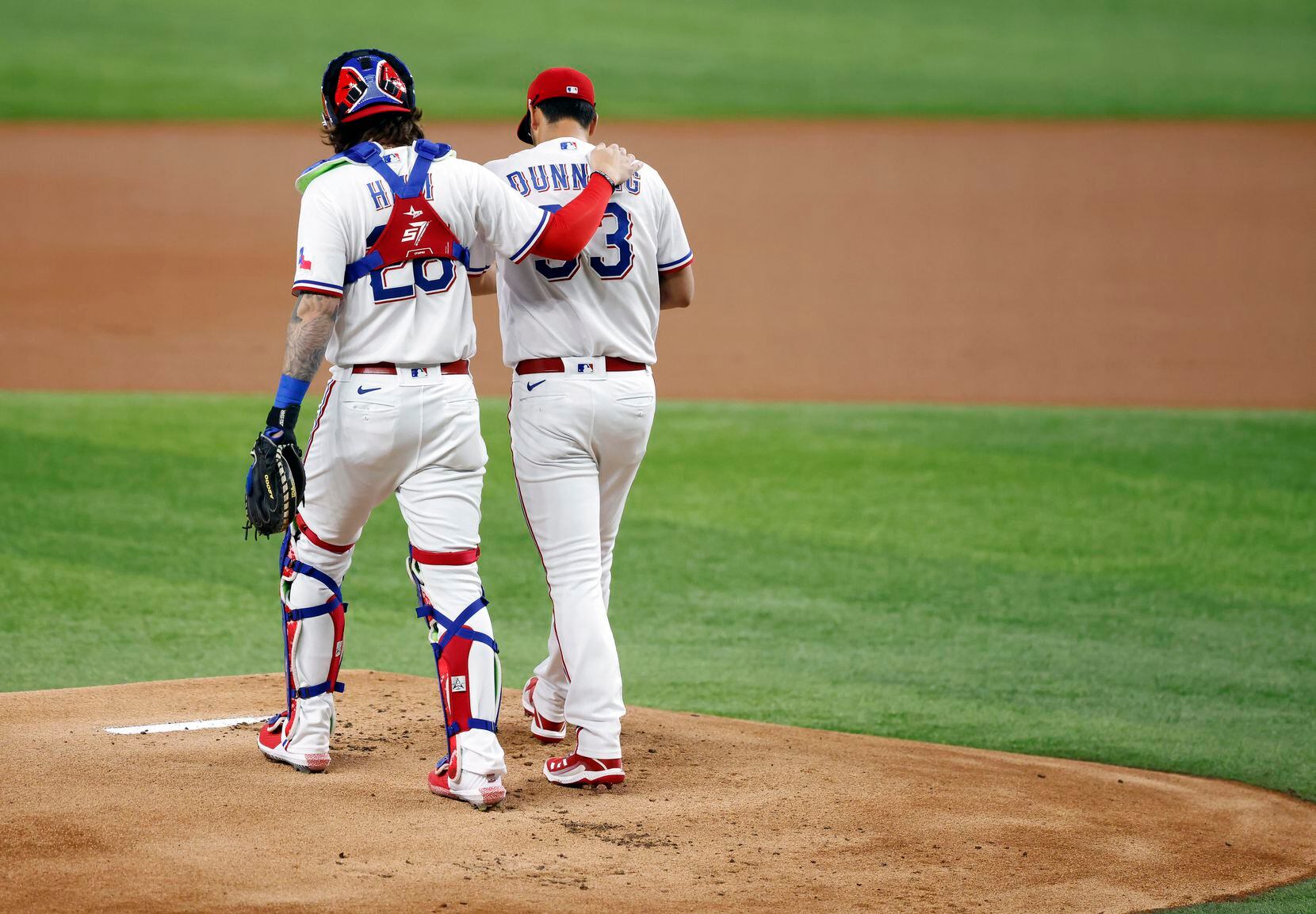 Texas Rangers catcher Jonah Heim (28) walks starting pitcher Dane Dunning (33) back to mound after he got off to a rough start against the Los Angeles Angels in the first inning at Globe Life Field in Arlington, Texas, Wednesday, April  28, 2021. (Tom Fox/The Dallas Morning News)