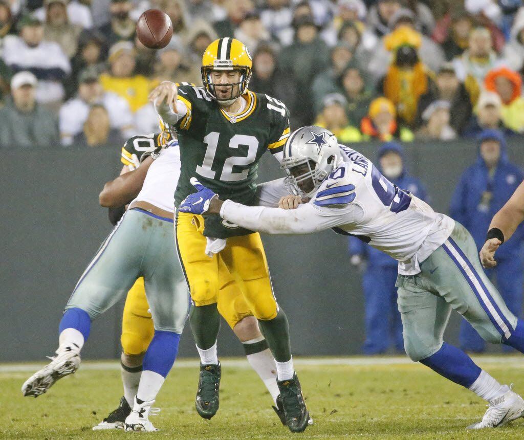 Green Bay Packers quarterback Aaron Rodgers (12) gets a pass off despite pressure from...