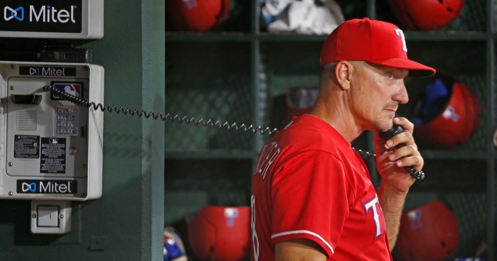 Texas Rangers manager Jeff Banister (28) gets on the phone to the bullpen during the...