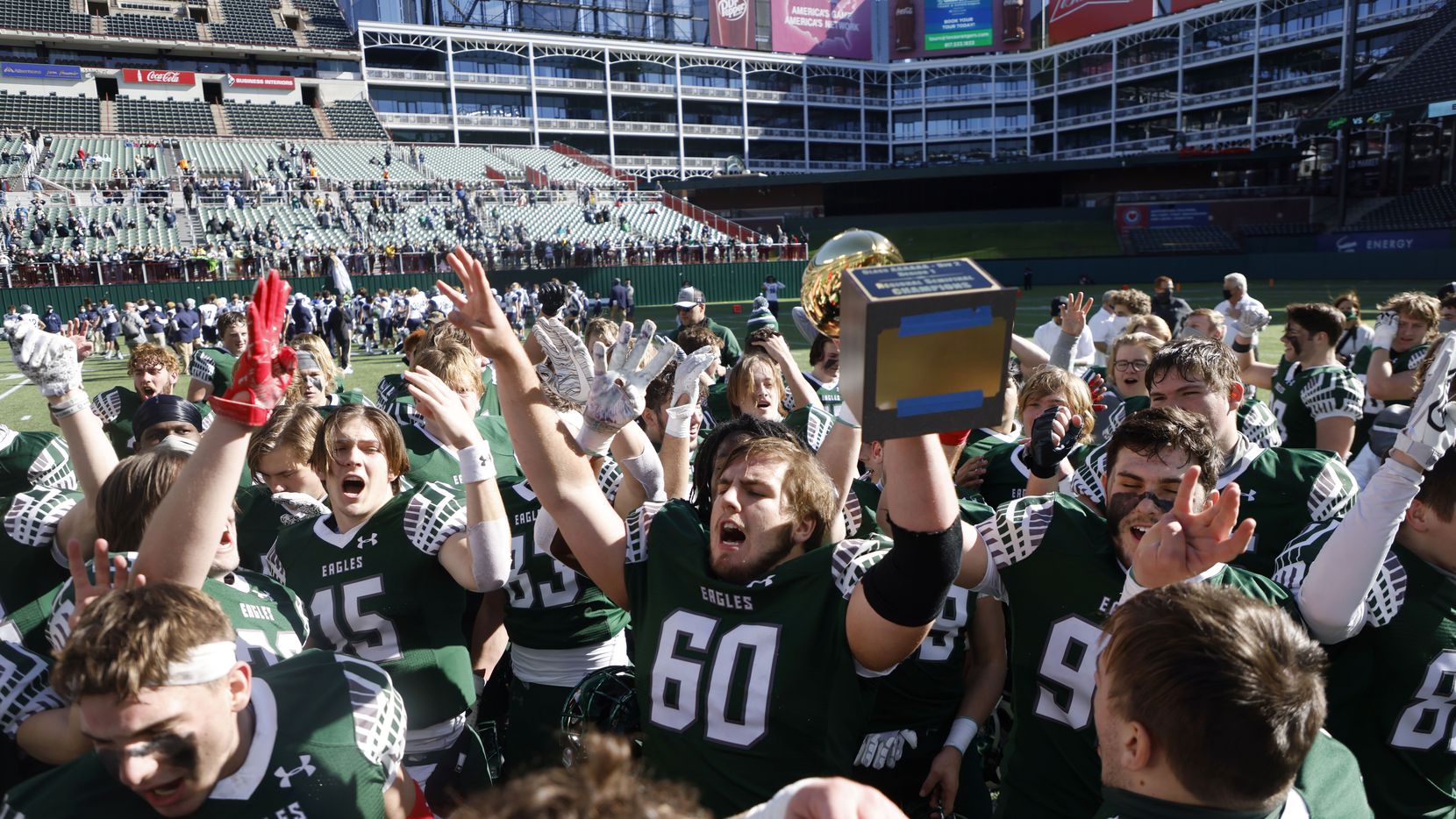 Prosper’s Nash Gagliano (60) holds the semifinal trophy after they defeated Northwest Eaton...