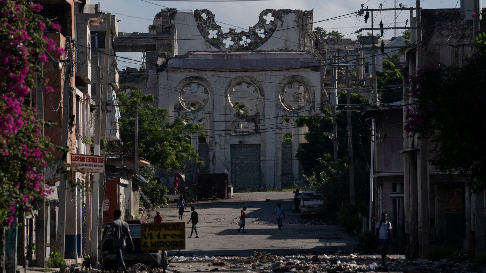 Gente camina cerca de las ruinas de la Catedral de Nuestra Señora de la Asunción destruida...