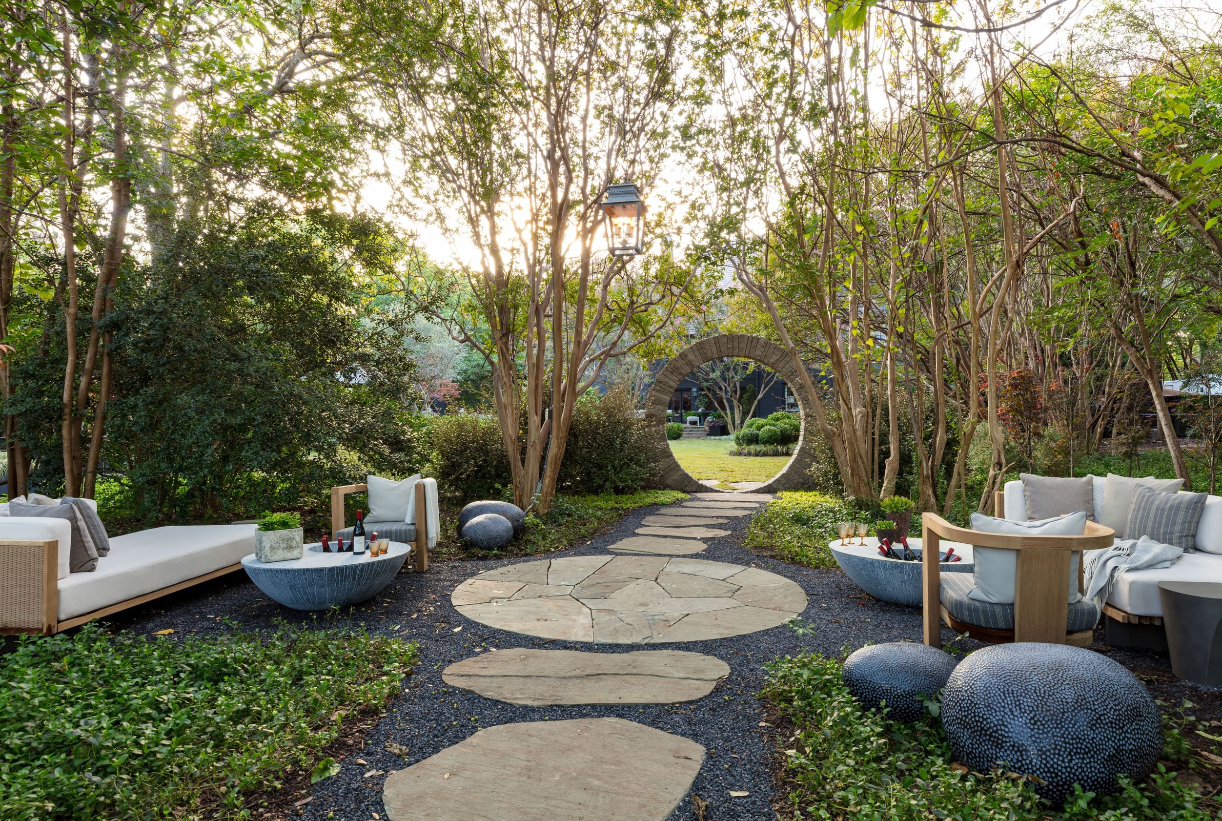 A moon gate leads to “the Woodland Garden,” which is an outdoor living room furnished with...