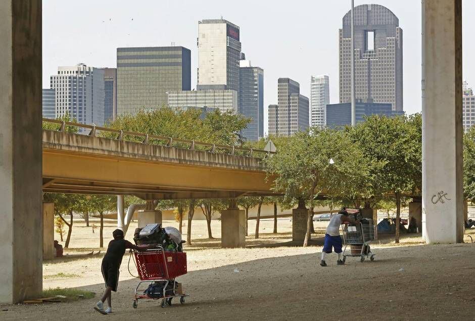 
Homeless men move their belongings back under Interstate 45 near downtown Dallas hours...