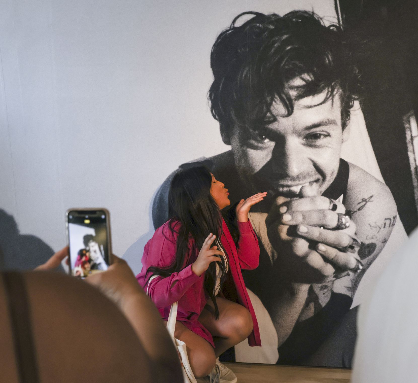 Itzel Ramirez blows a kiss to photo of Harry Styles while posing for a photo on Friday, May...