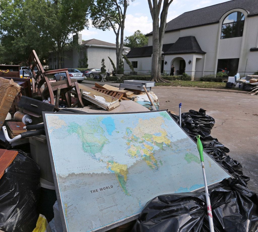 A map of the world shows the waterline of the flood waters as it sits in the trash outside...