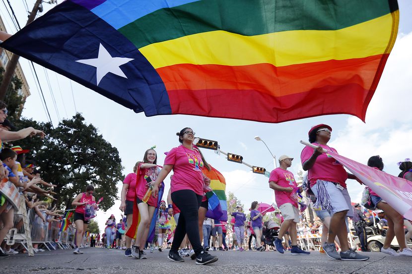 People marching with the Mobilize for Equality group pass by the Texas rainbow flag during...